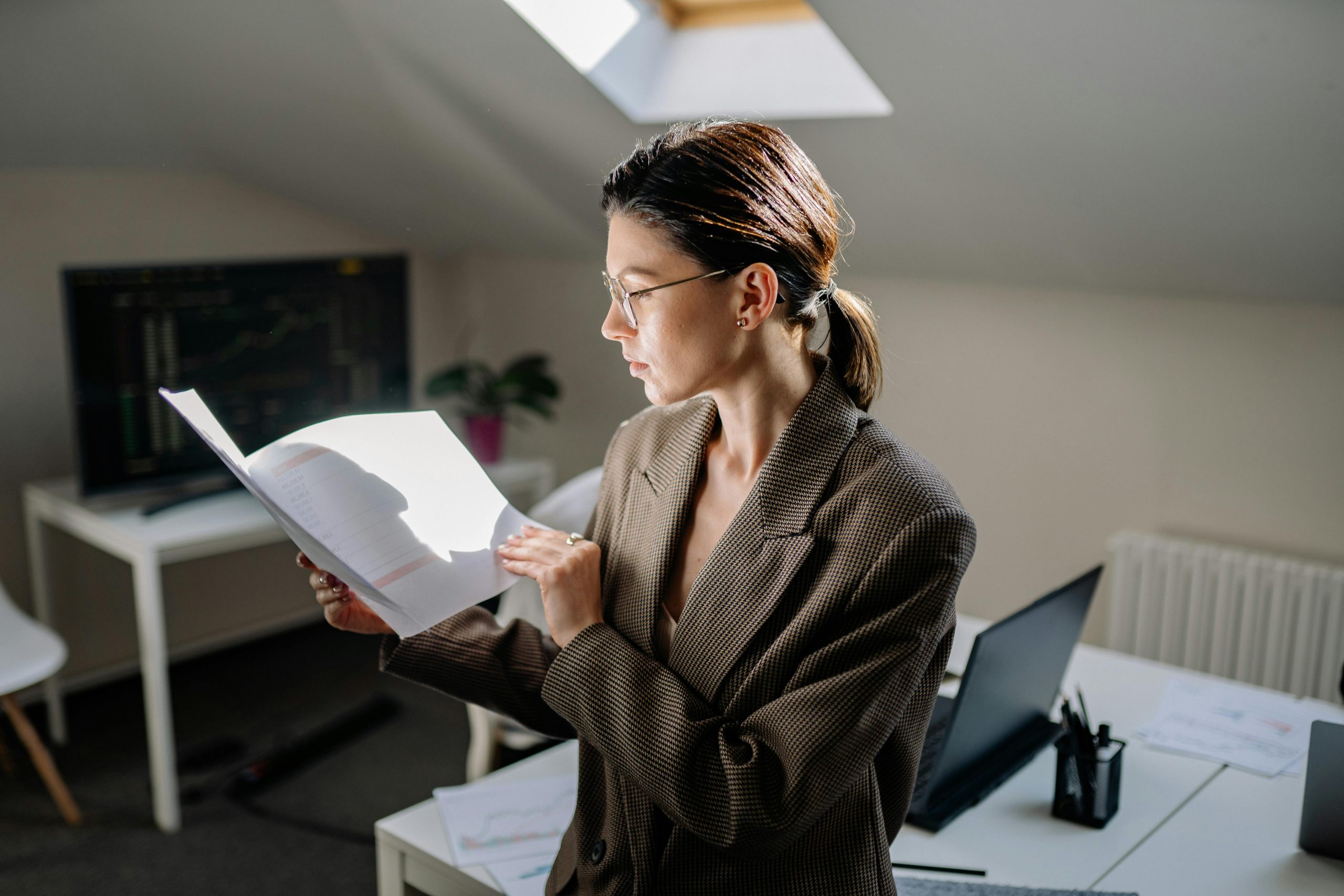 Professional woman in glasses reviewing financial documents at her office desk — illustrating: The PDF editor I’d pick over Adobe’s subscription: PDFelement vs UPDF breakdown