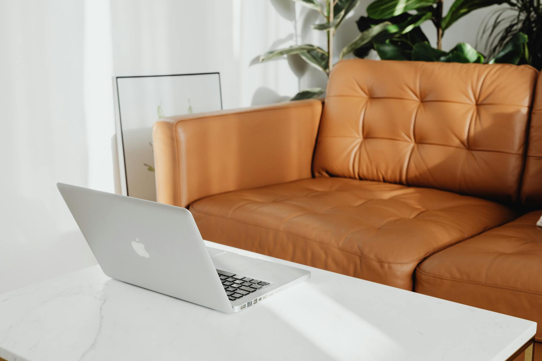 A cozy living room with a laptop on the coffee table, perfect for relaxation — illustrating: Which home security system actually makes sense for busy families? Ring vs SimpliSafe vs ADT