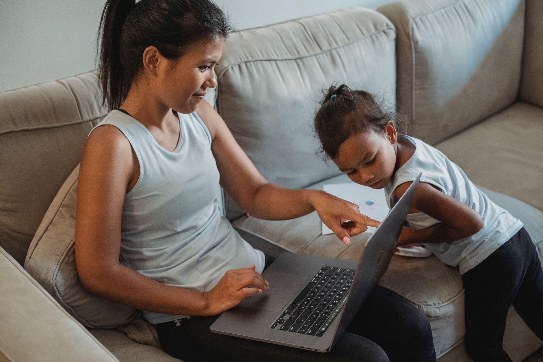 Mother and daughter surfing through internet on netbook on couch in living room in daytime — illustrating: Is your family's computer backup actually reliable? Here's what real owners report about speed and peace of mind
